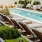 Rows of reclining seats and near lush landscaping beside pool at The Registry on the Park